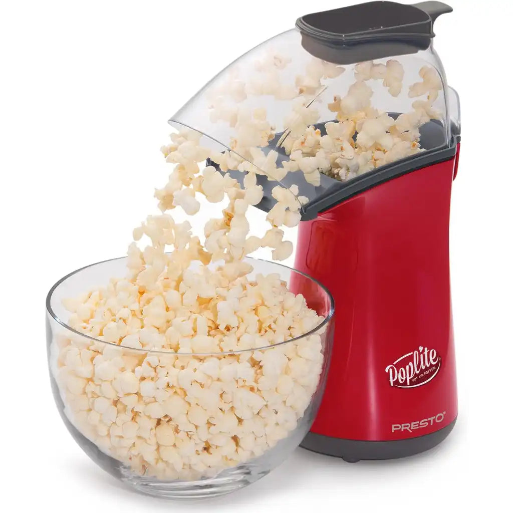 Red air pop popcorn popper dispensing popcorn into a glass bowl on a white background.