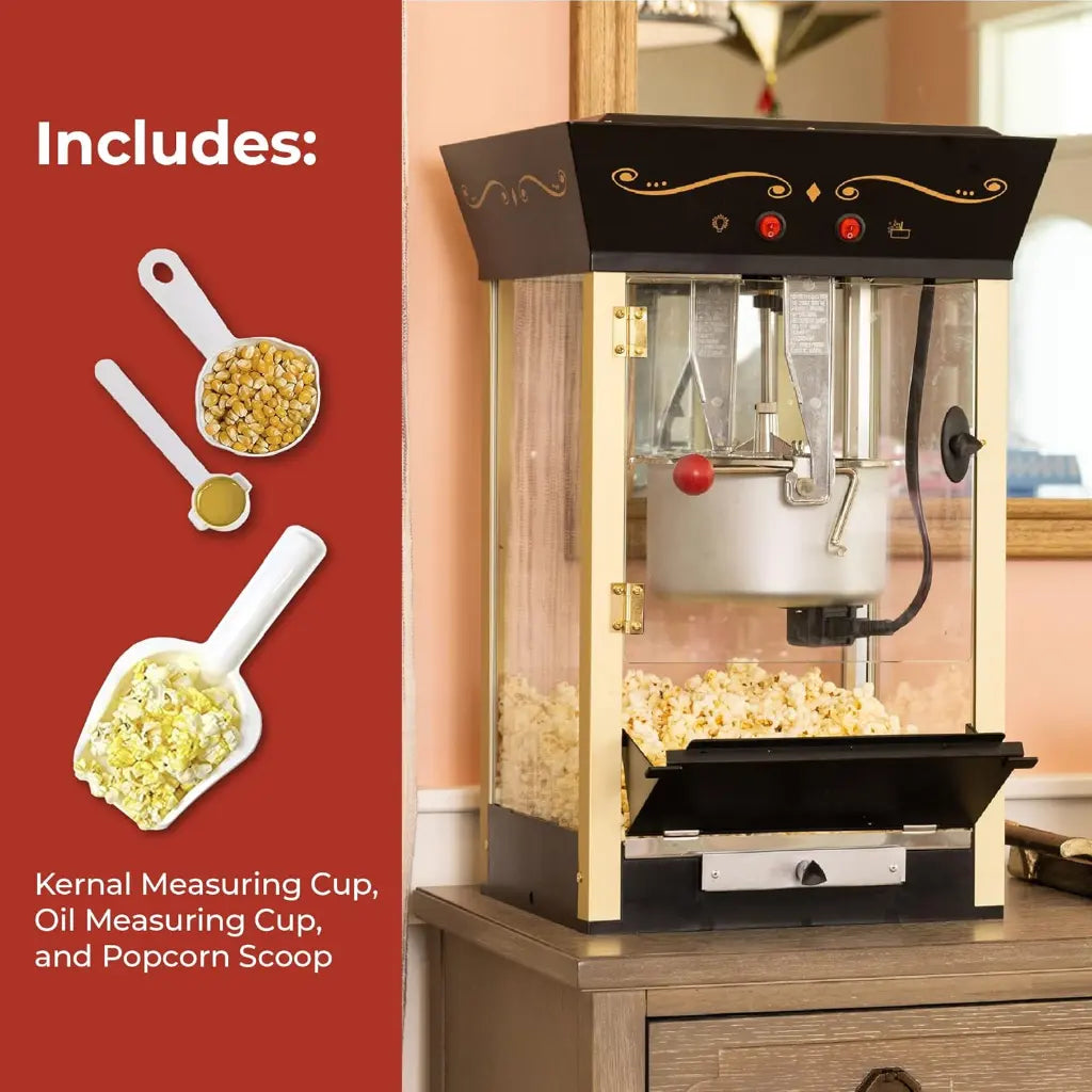 Black home movie theater popcorn machine with accessories on a wooden surface.