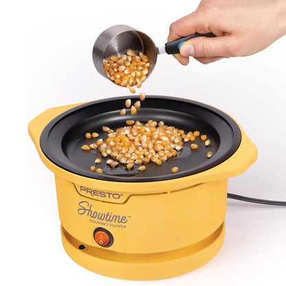 Yellow Presto Showtime, oil popcorn popper with a hand pouring popcorn kernels.