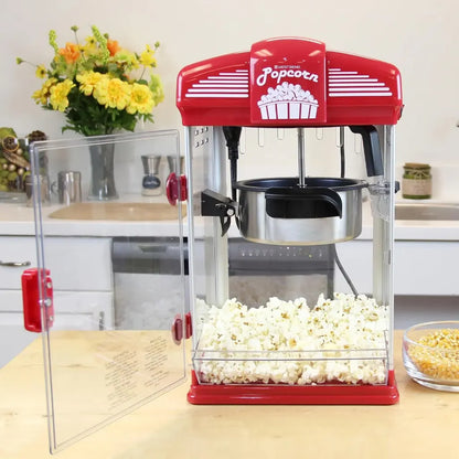 Popcorn popper machine on a kitchen counter with popped popcorn inside.